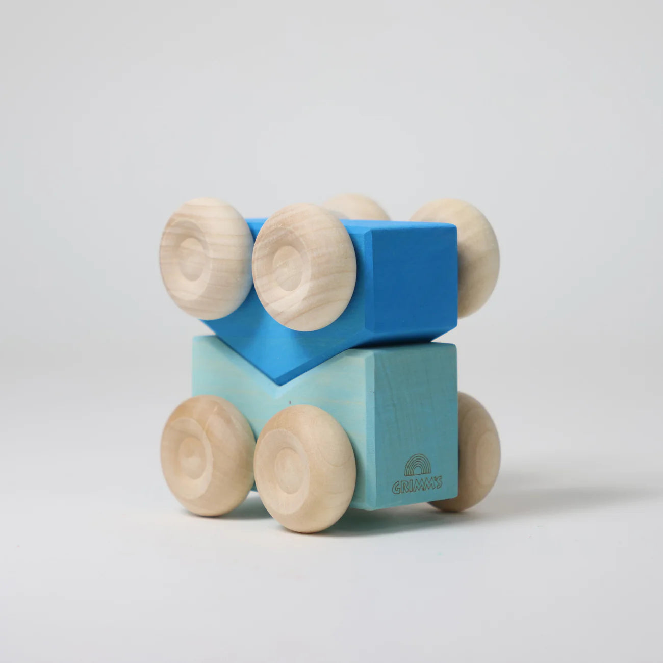 Wooden toy blocks with wheels on a light gray background