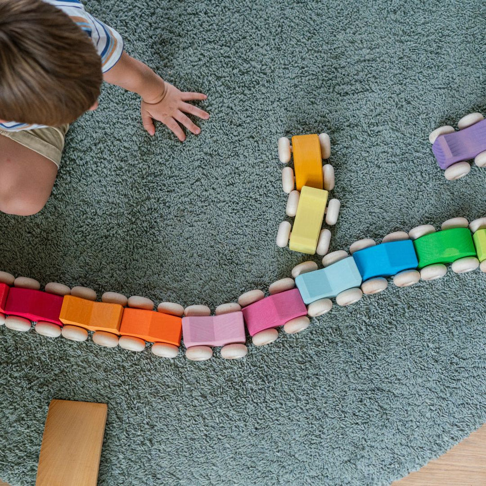 Child playing with colorful building blocks on a carpeted floor