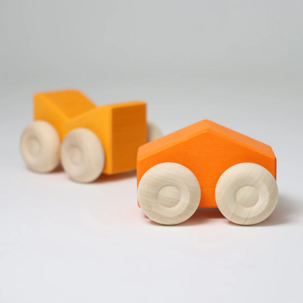 Two orange wooden toy cars with white wheels on a light gray background