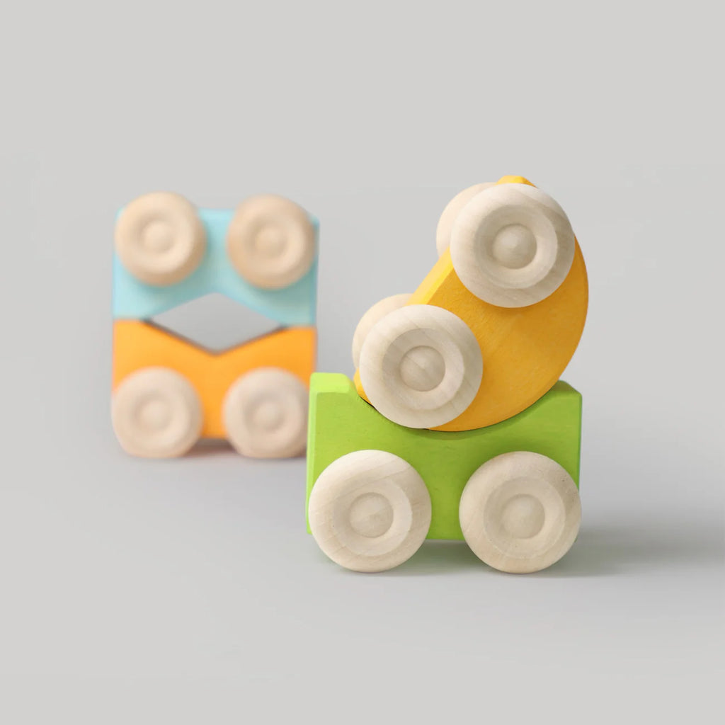 Colorful wooden toy blocks with wheels on a gray background