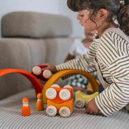 Children playing with colorful wooden toys on a couch