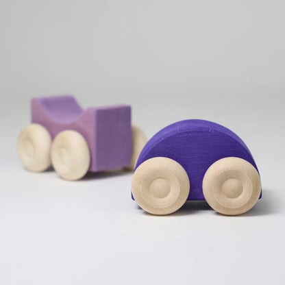 Purple wooden toy car with beige wheels on a light gray background