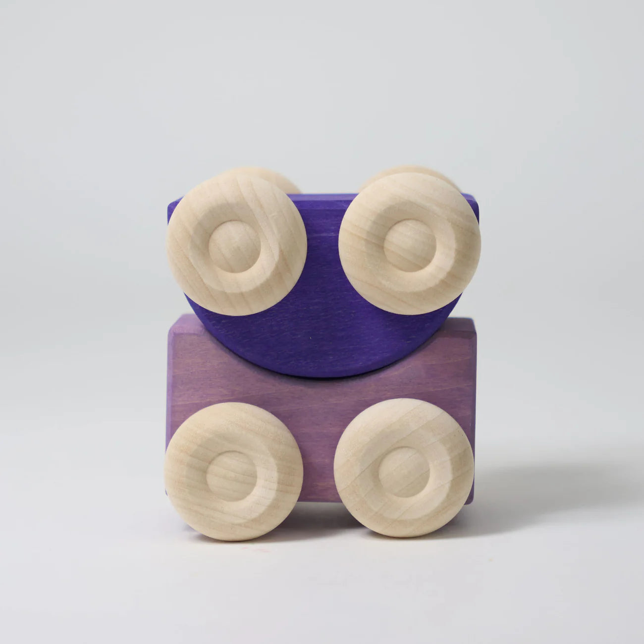 Wooden toy train with purple car and beige wheels on a light gray background