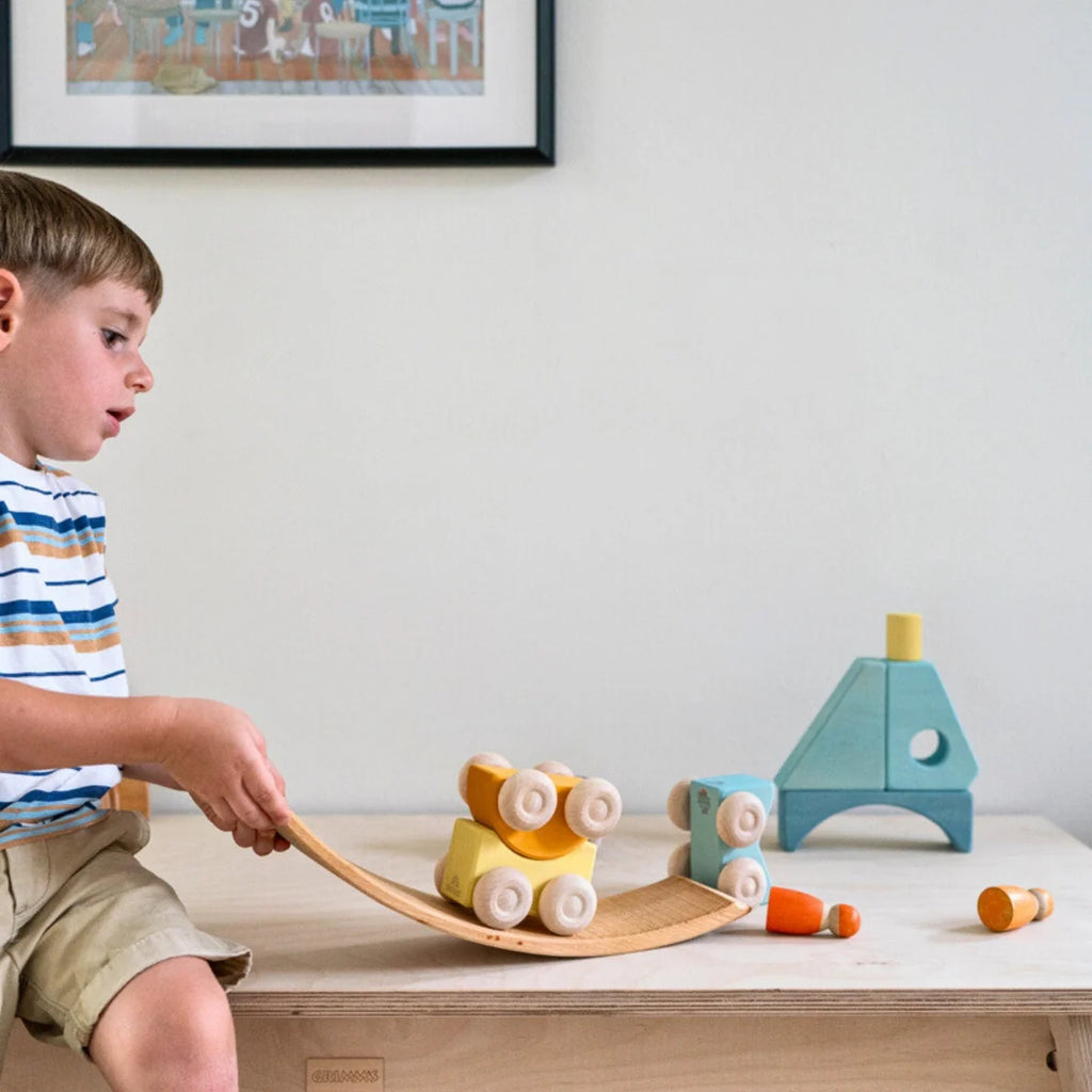 Child playing with wooden toys on a table