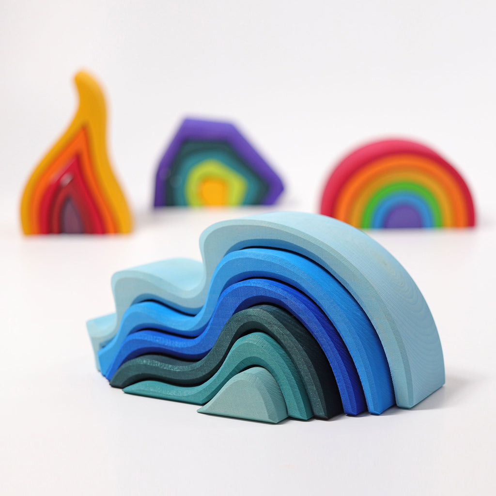 Stack of colorful wooden rainbow toys on a white background