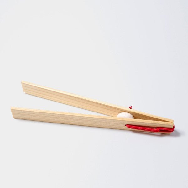 Wooden tongs with a red handle on a white background