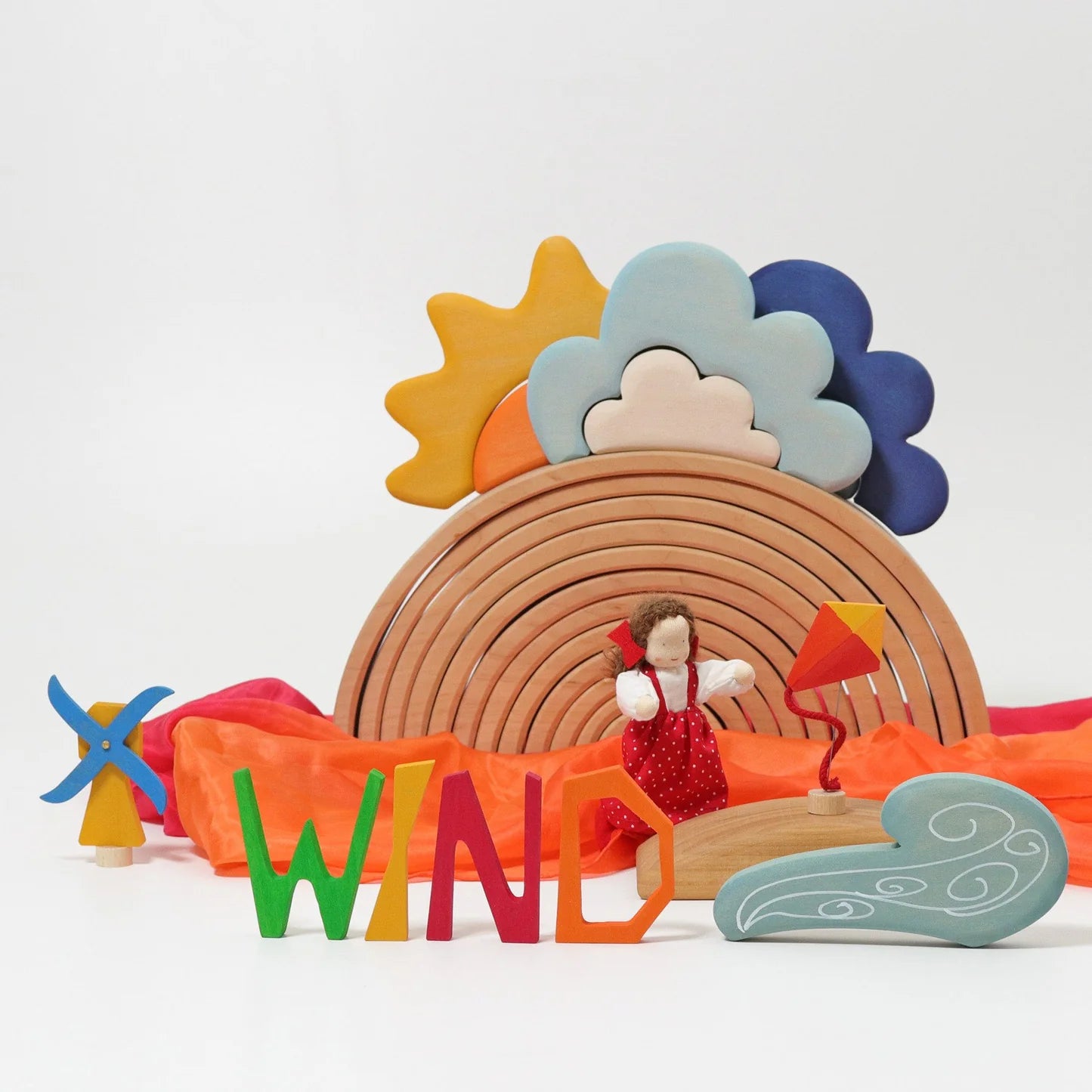 Colorful toy set with a rainbow, sun, clouds, and wind-themed elements on a white background.