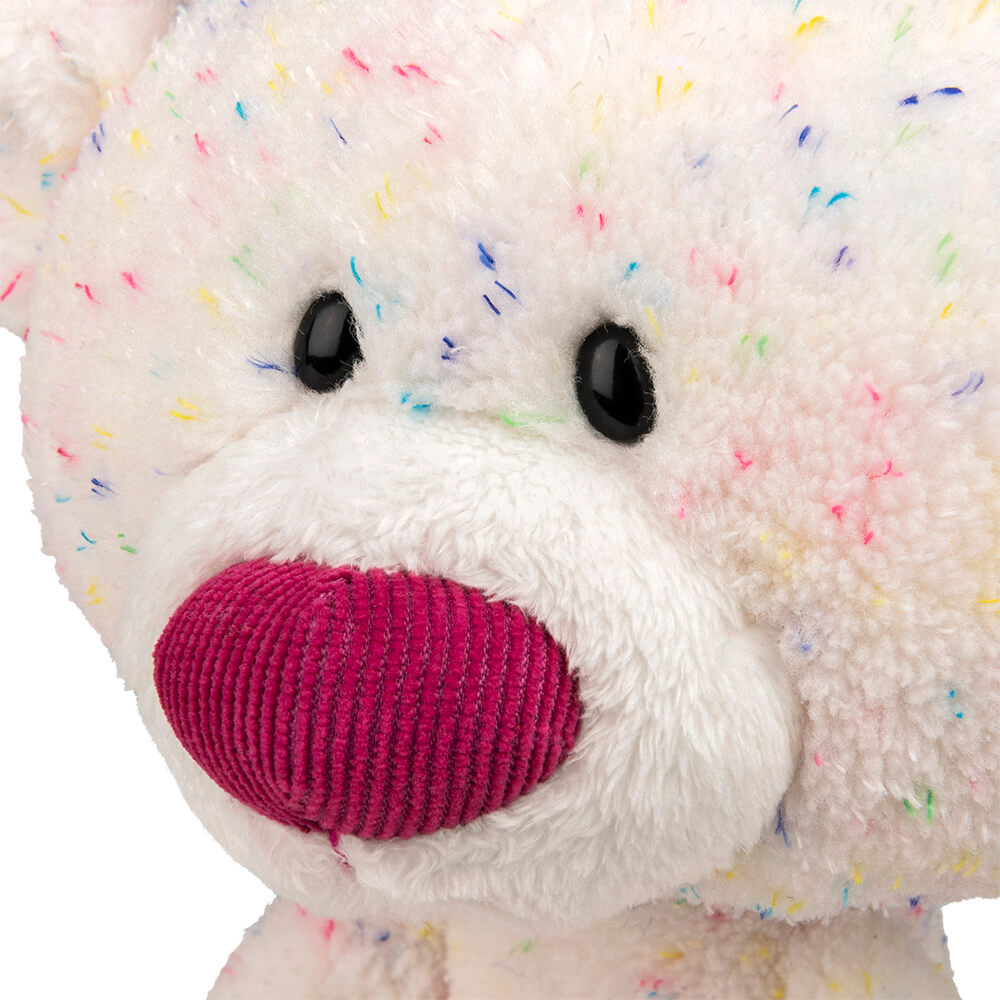 Close-up of a plush toy with colorful sprinkles on a white background