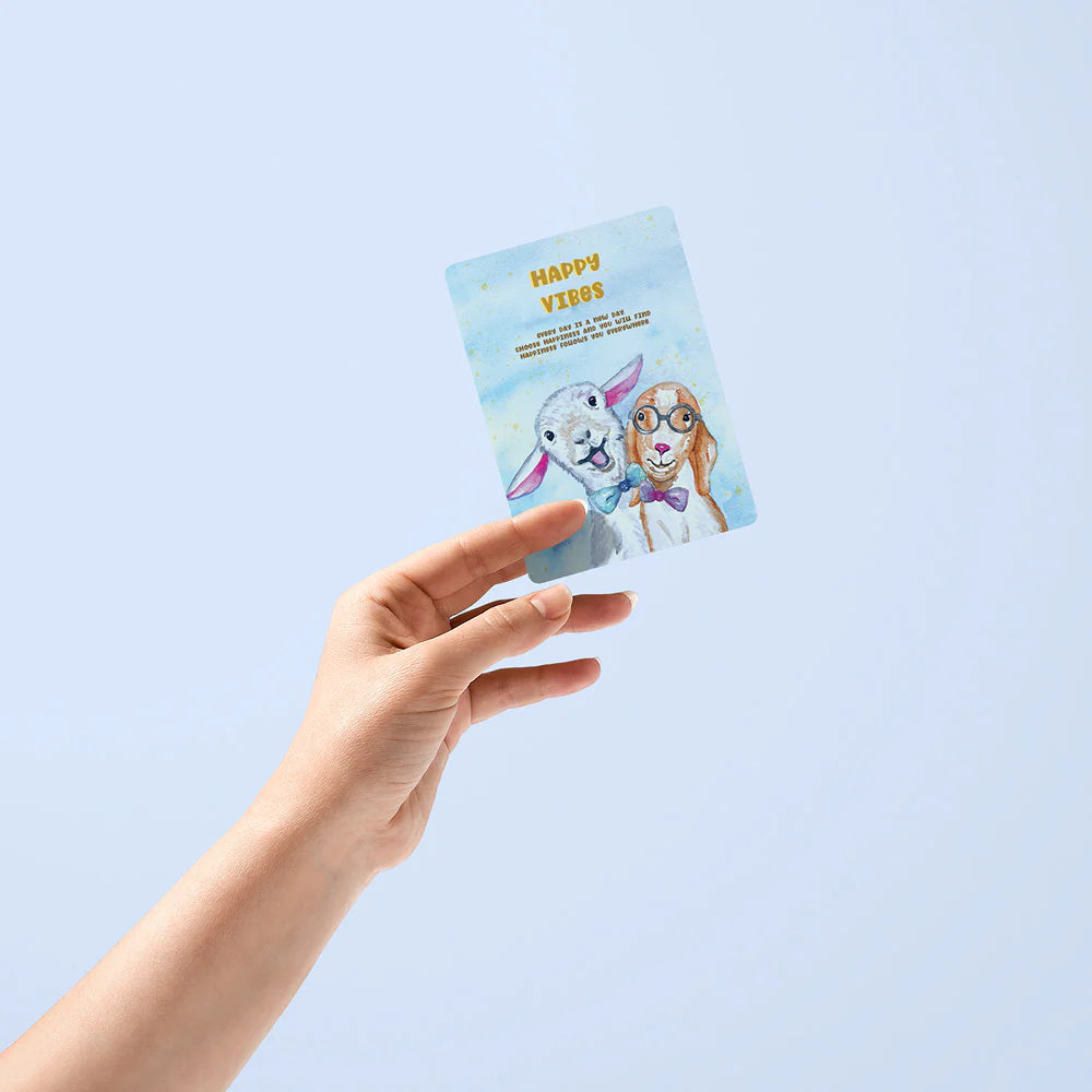 Hand holding a card with cartoon characters on a light blue background