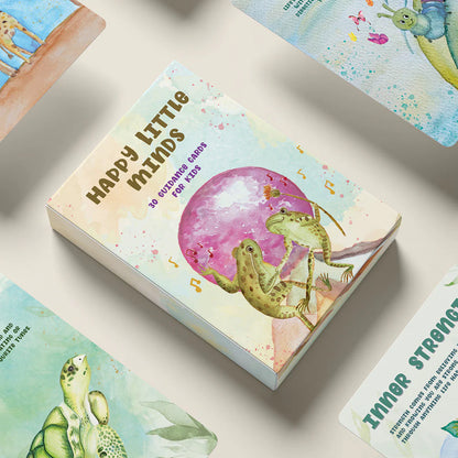 Card game box titled 'Happy Little Minds' with frog illustration on a light background