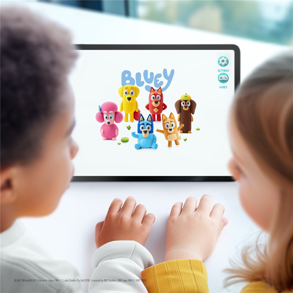 Two children interacting with a tablet displaying the Bluey cartoon characters.