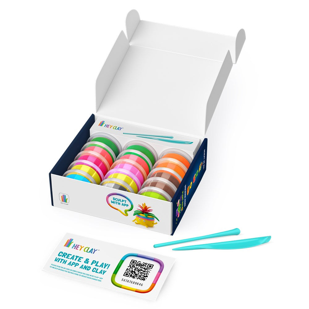 A toy clay kit in an open white box with three rows of colorful clay pots, two turquoise sculpting tools, and a printed card in front on a white background. The box and card show the brand name Hey Clay.