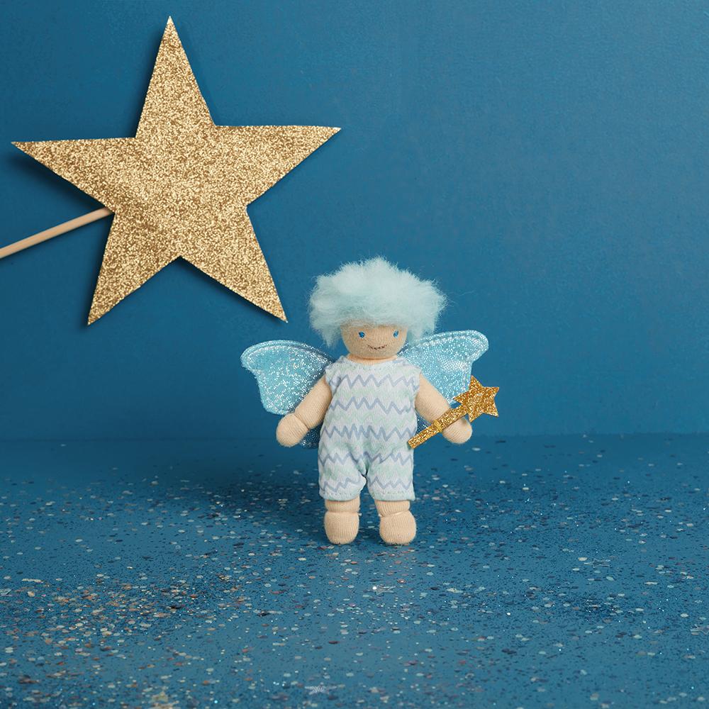Toy fairy with wings and a wand on a blue background