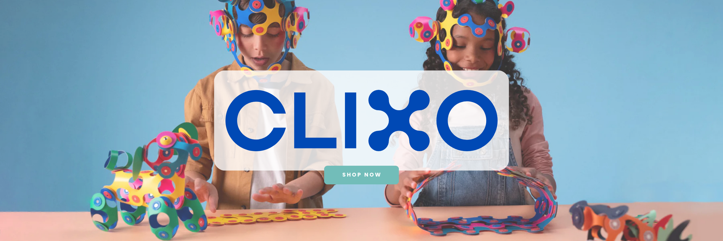 Two children with colorful headbands holding a Clixo sign against a blue background