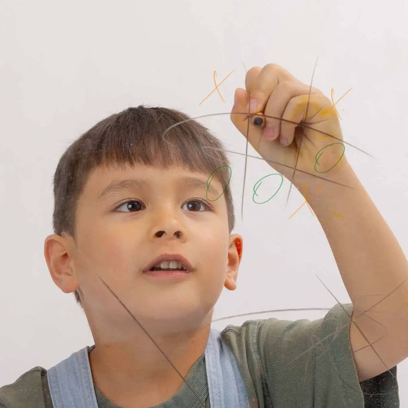 Child playing with a string toy against a white background