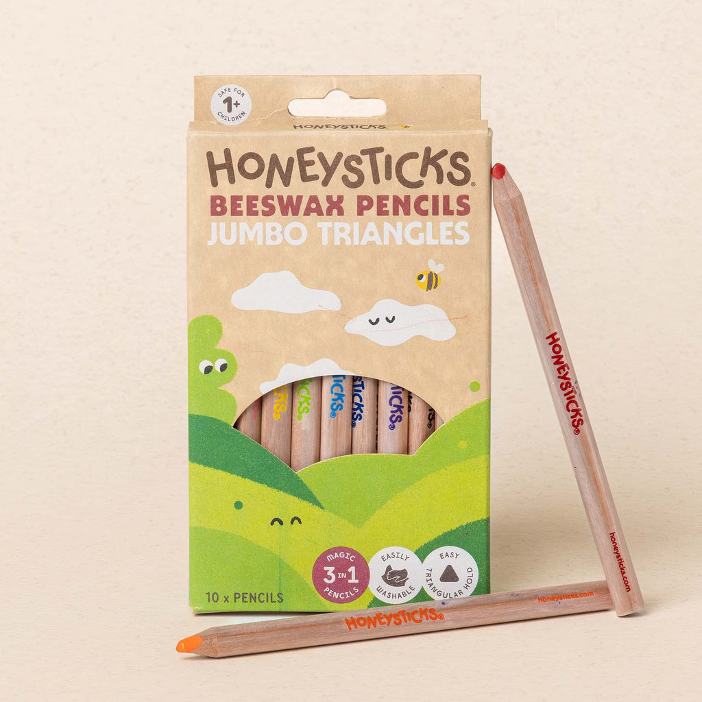 Honeysticks beeswax pencils in a packaging with a pencil leaning against it on a beige background