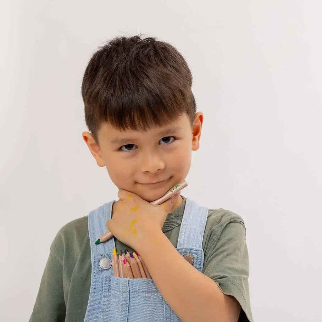 Child holding colored pencils against a plain background