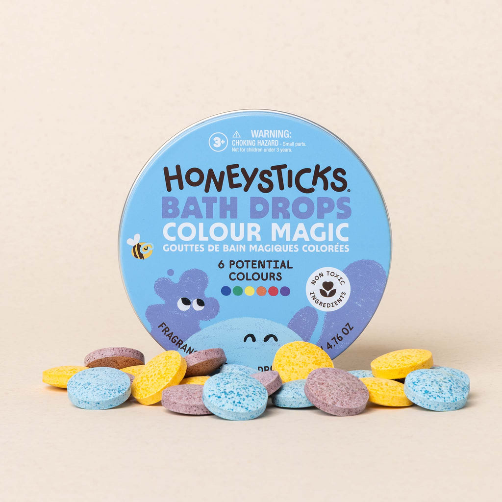 Honeysticks Bath Drops Colour Magic packaging with bath bombs on a beige background