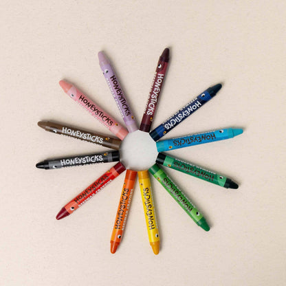 Colorful crayons arranged in a circular pattern on a beige background