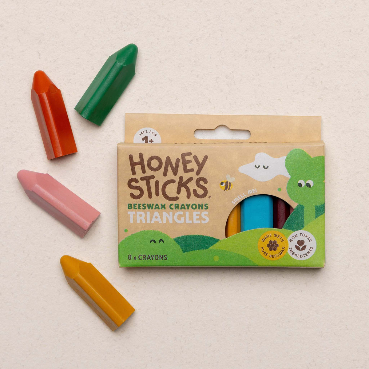 Pack of Honey Sticks Beeswax Crayons Triangles with colorful crayons on a beige background
