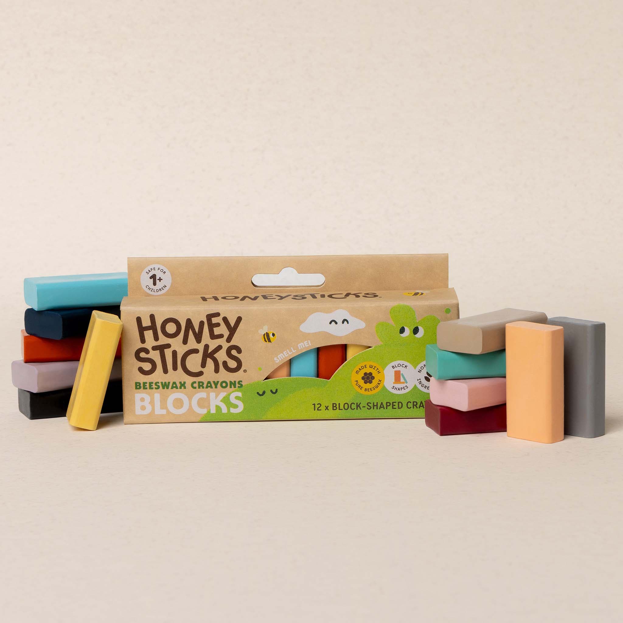 Honey Sticks crayon blocks with packaging on a beige background