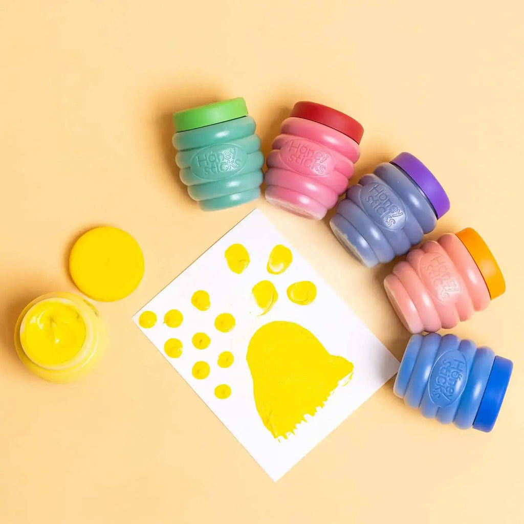 Colorful stampers with a paw print template on a yellow background