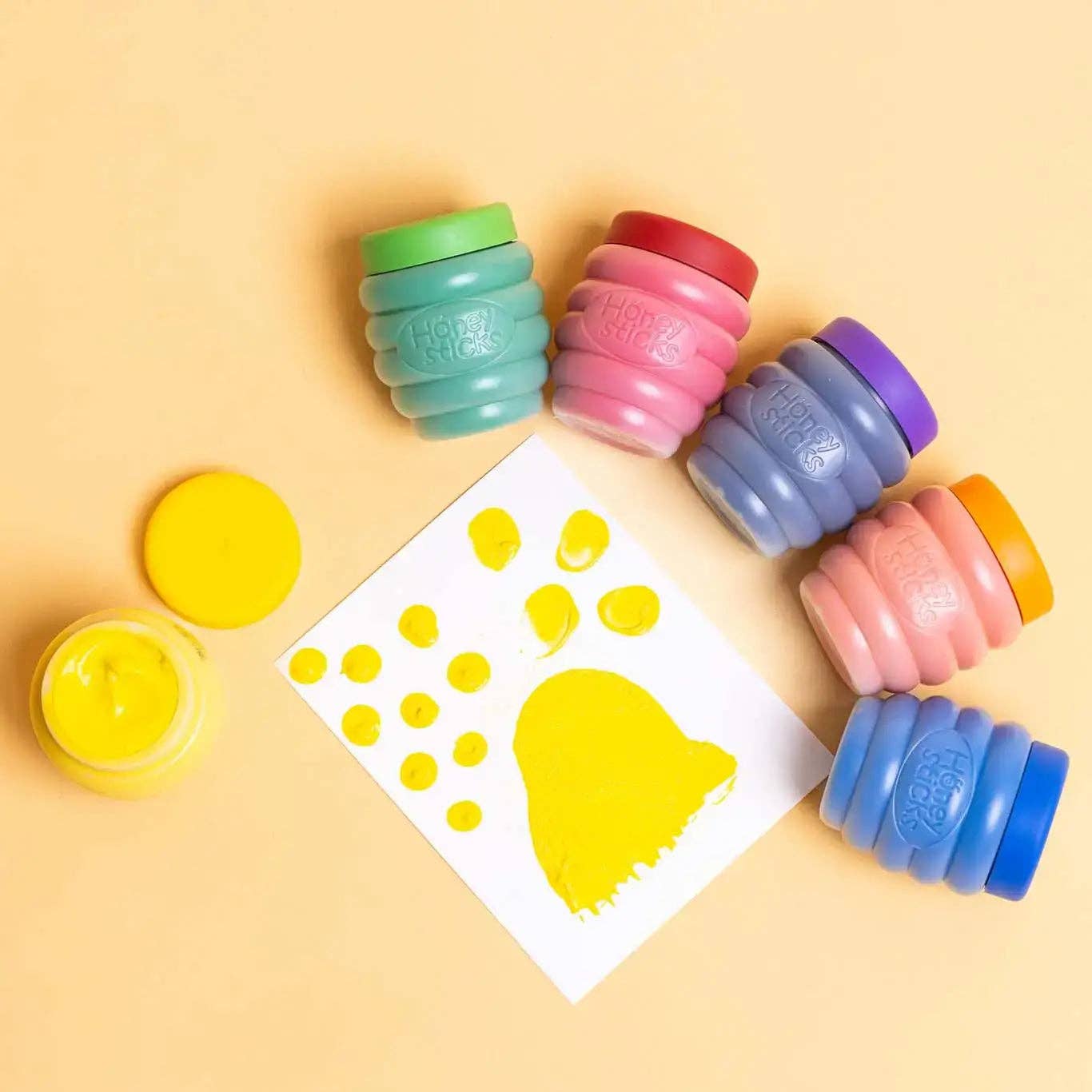 Colorful stampers with a paw print template on a yellow background