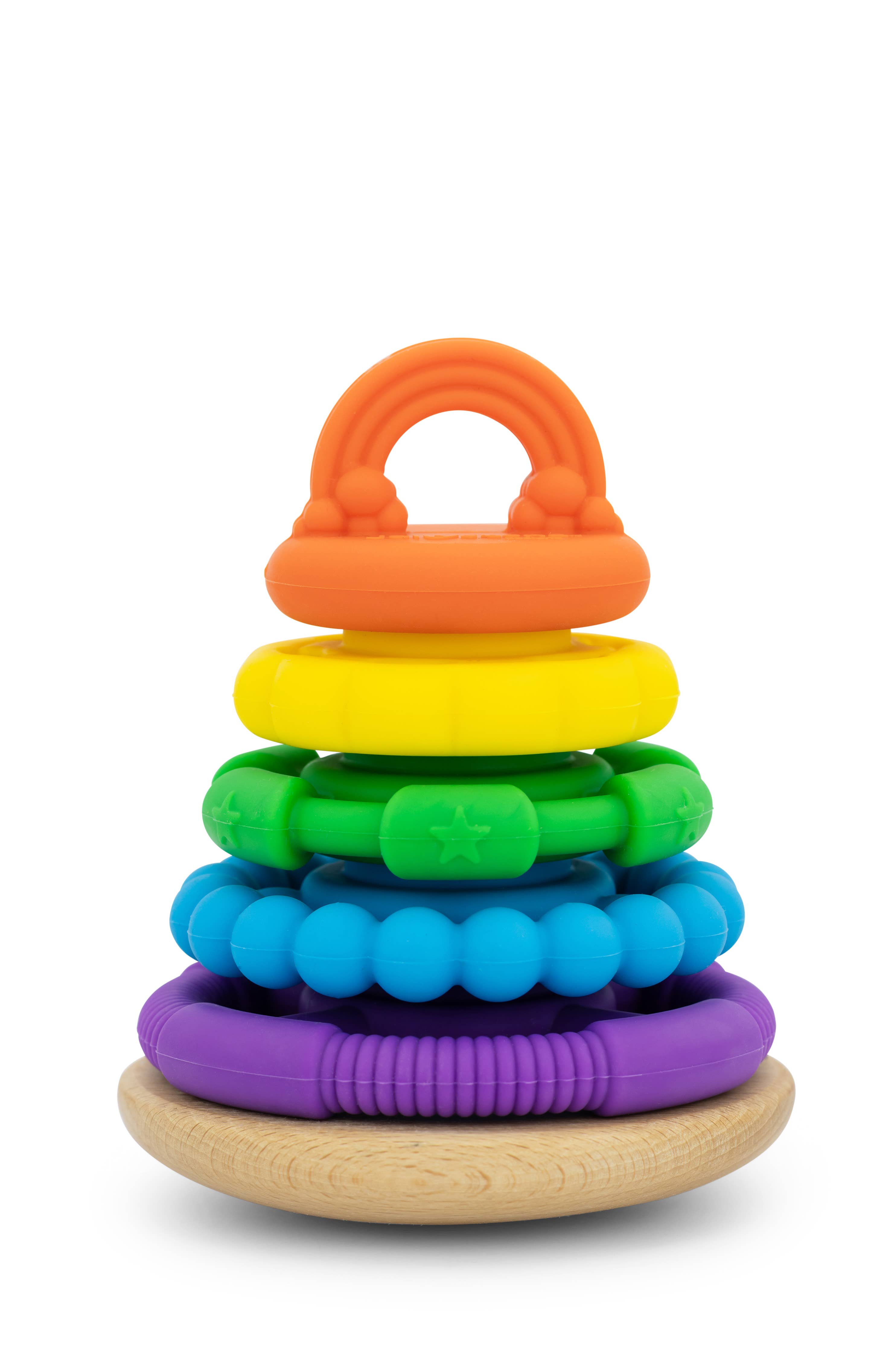 A colourful stacking toy made of beech wood with a series of round rings in rainbow colours, stacked on top of each other with a wooden base.