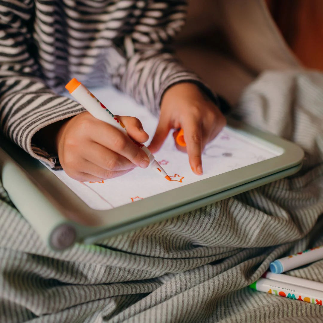 Child drawing on a tablet with colorful markers