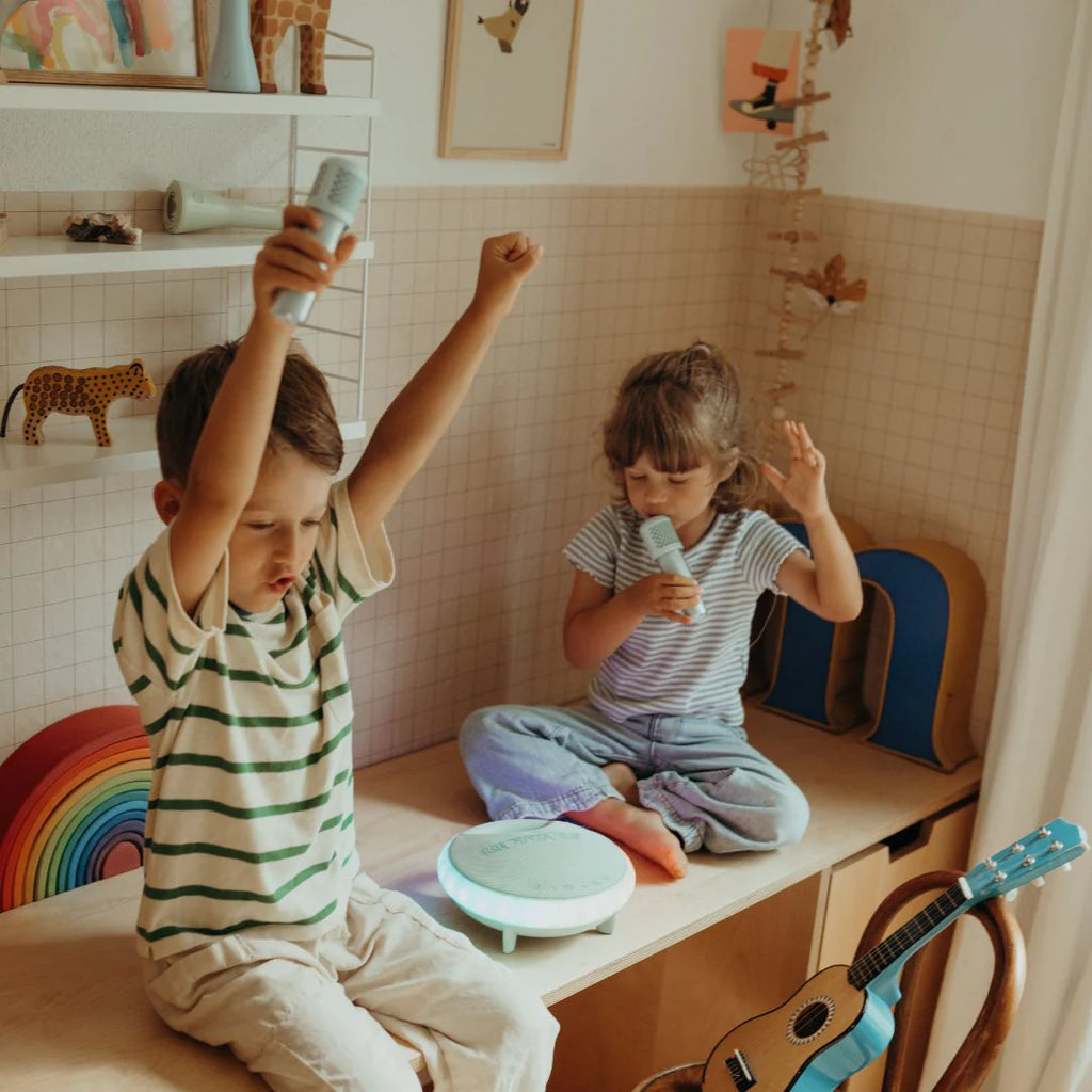Two children playing with toys in a room with a rainbow decoration.