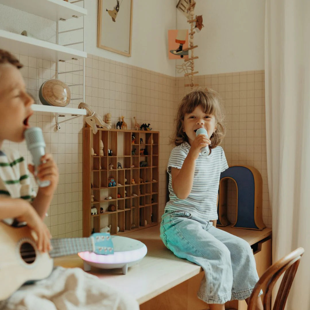 Two children in a room with musical instruments and toys.