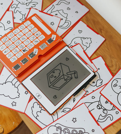 Children's drawing tablet with stamps on a wooden surface with coloring sheets.