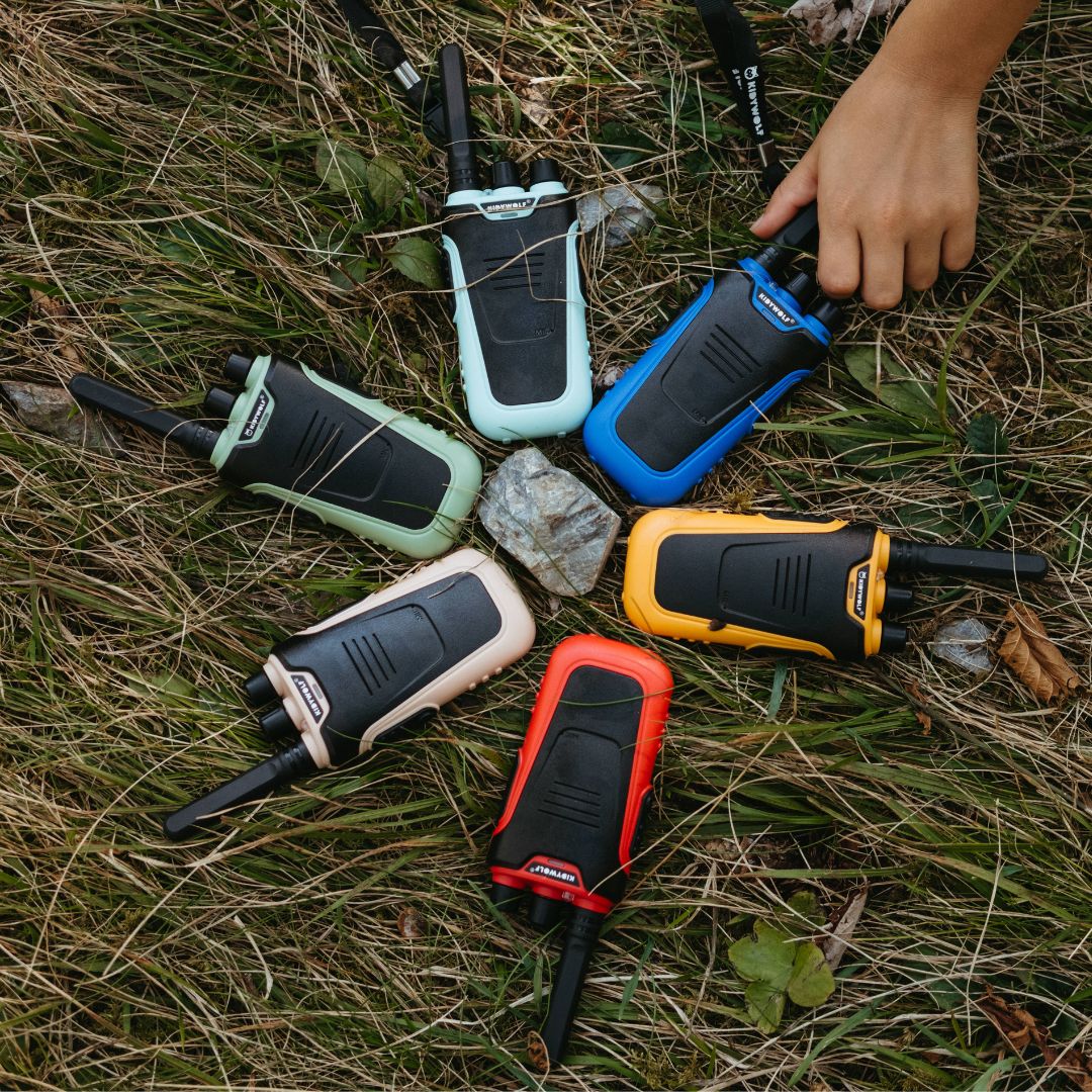 Six walkie-talkies in different colors on grass