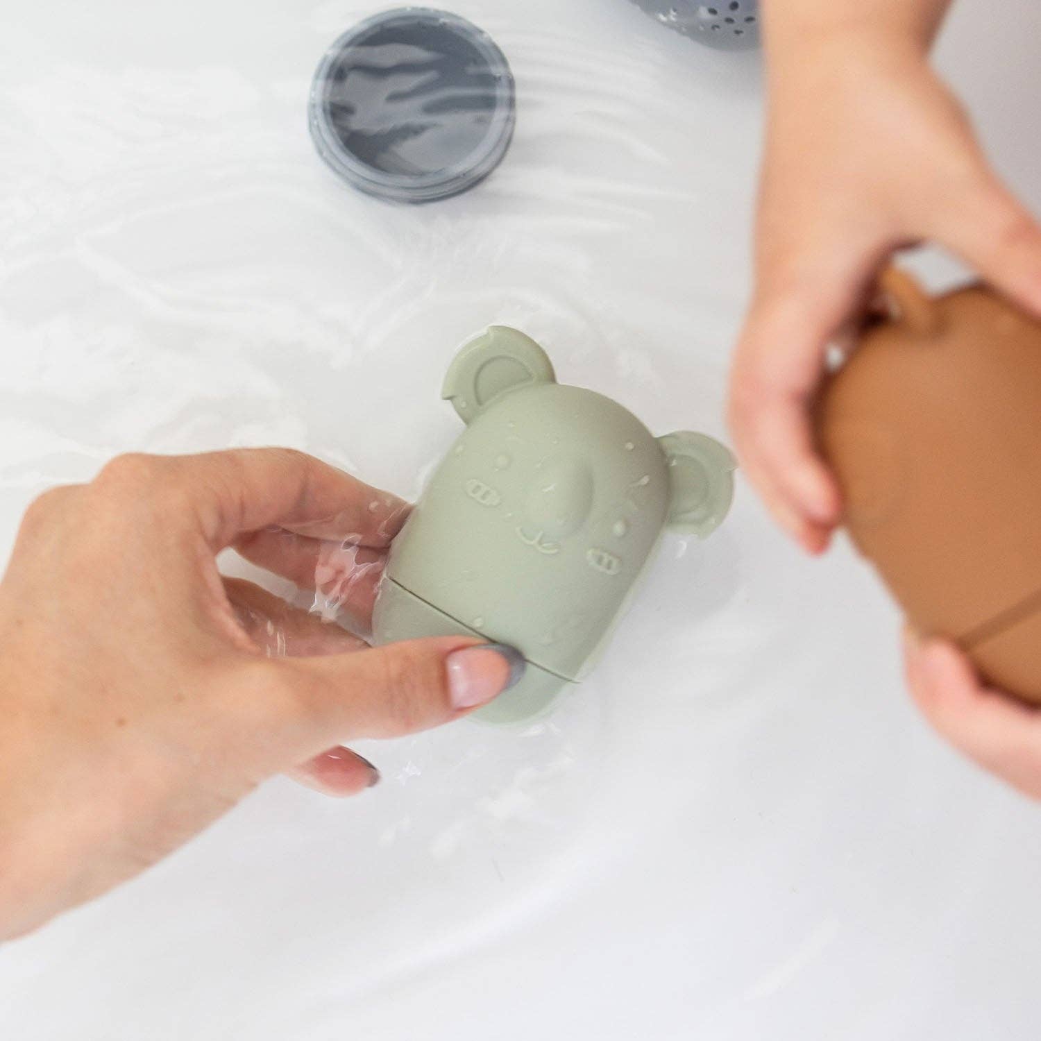 A set of five silicone bath toys in various colors, each shaped like an animal face.