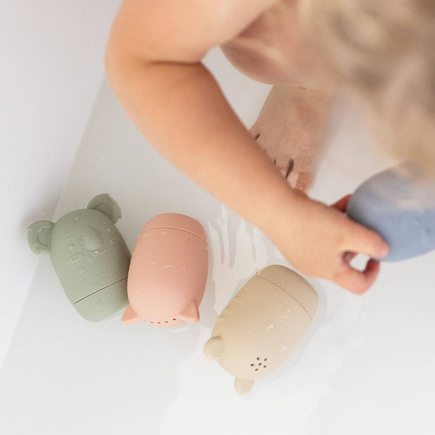 A set of five silicone bath toys in various colors, each shaped like an animal face.