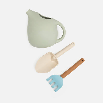 A set of silicone gardening tools including a watering can, a fork, and a trowel, in soft pastel colors.