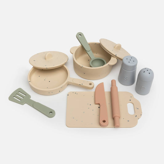 A silicone kitchen set for children including various utensils, pots, and a cutting board, all in soft pastel colors.