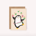 Greeting card with a penguin holding a hula hoop and cupcakes on a beige background