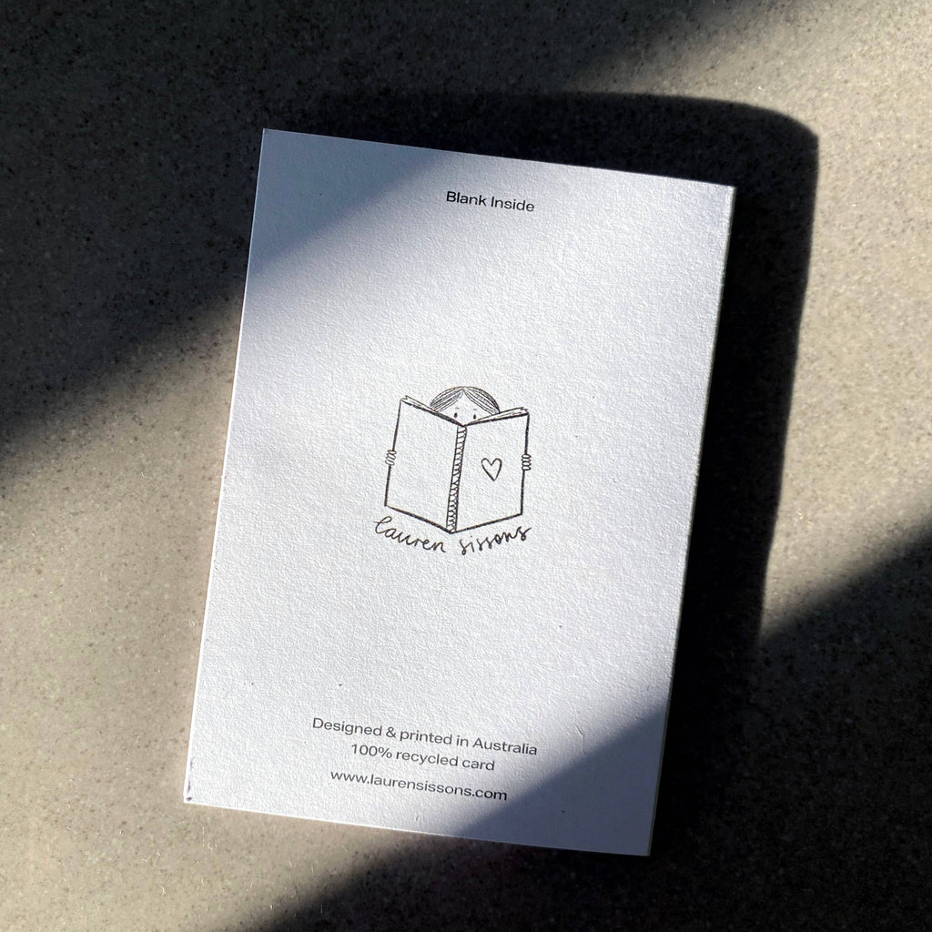 White card with black text and design on a textured surface