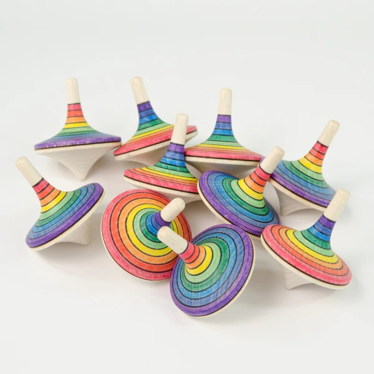 Set of rainbow-colored wooden spin tops on a white background