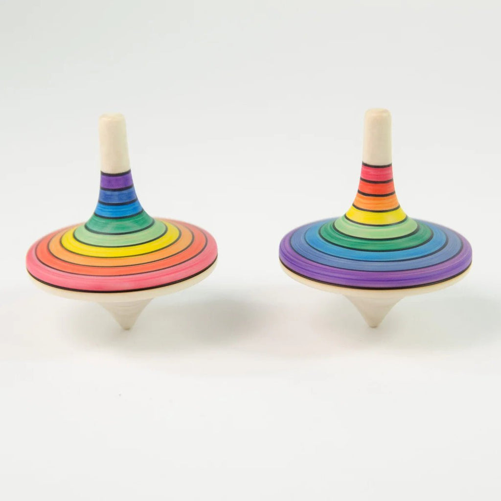 Two rainbow-colored wooden spin tops on a white background