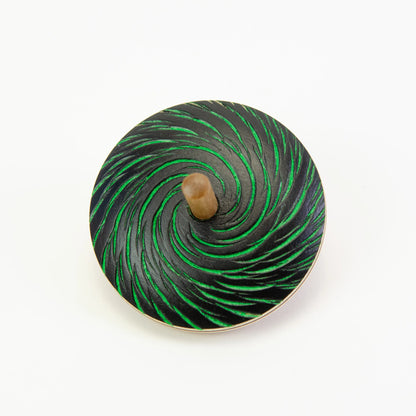 Spinning top with green and black spiral pattern on a white background