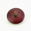 Spinning top with red and black spiral pattern on a white background