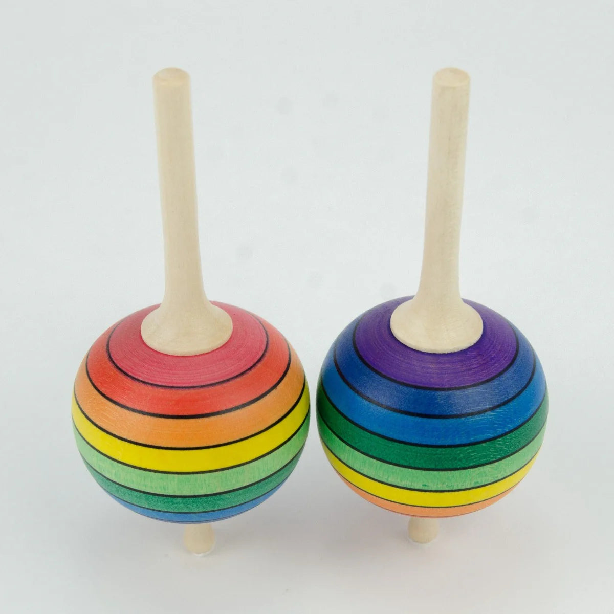 Two rainbow-colored wooden top toys on a white background