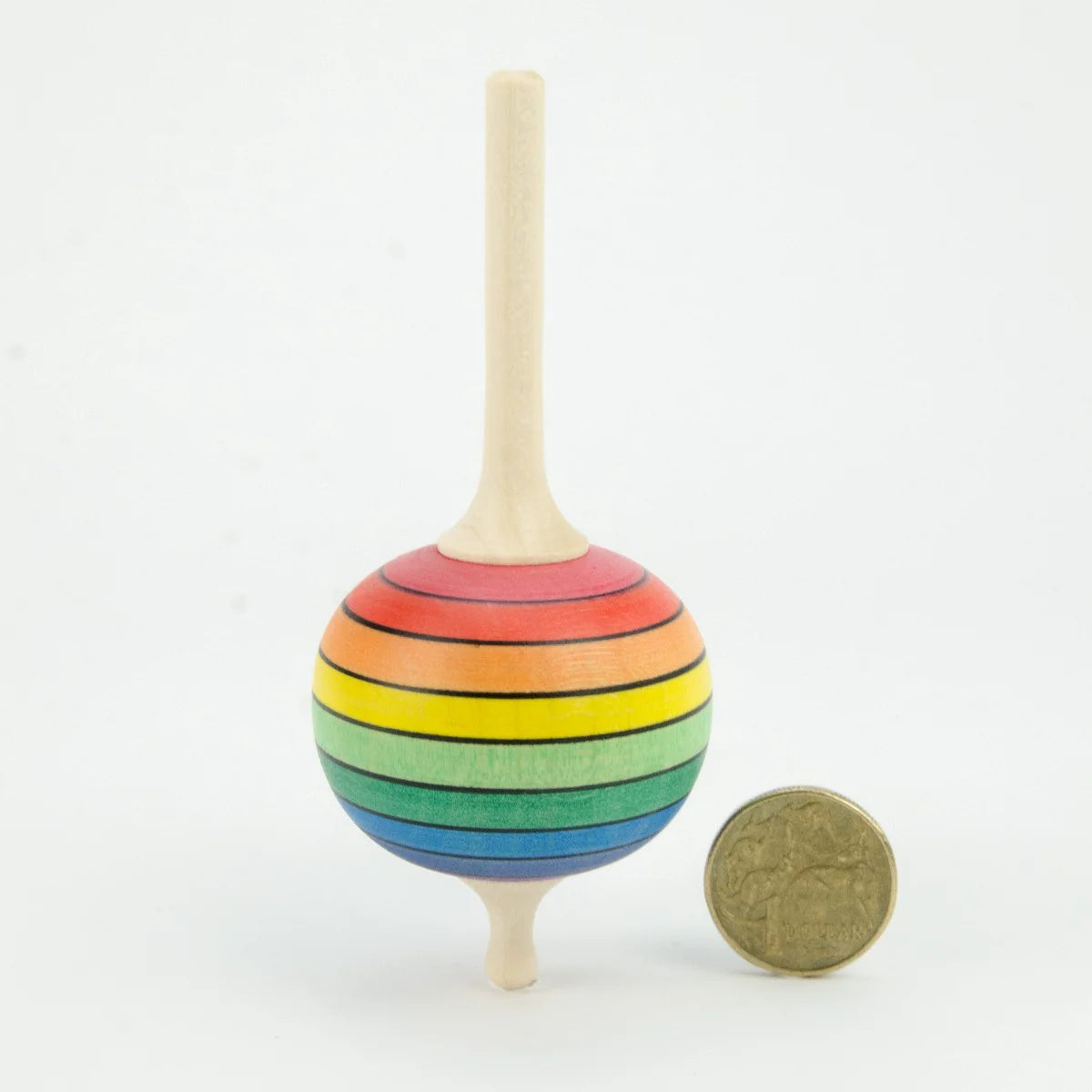 Colorful striped wooden top next to a coin on a white background