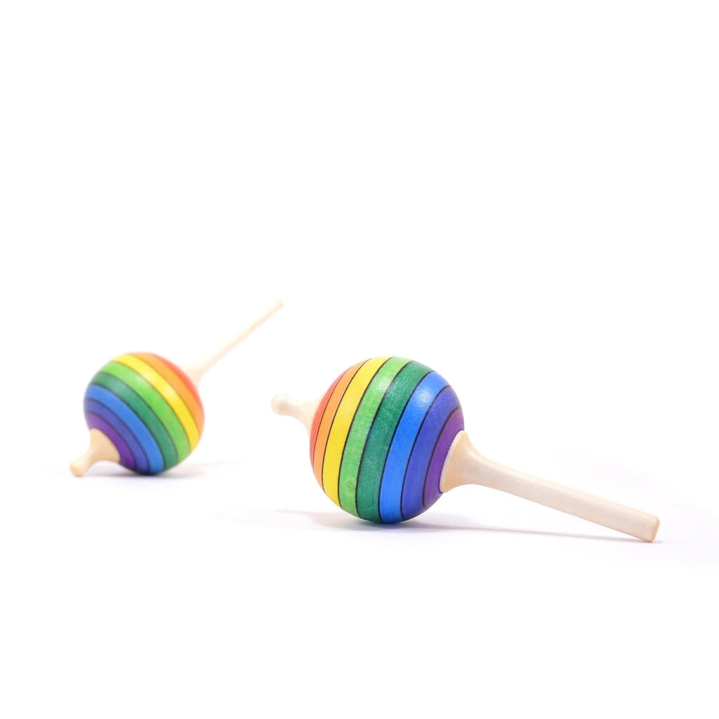 Two rainbow-colored wooden top toys on a white background