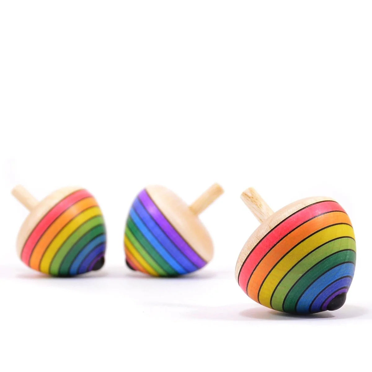 Three rainbow-striped wooden spinning tops on a white background