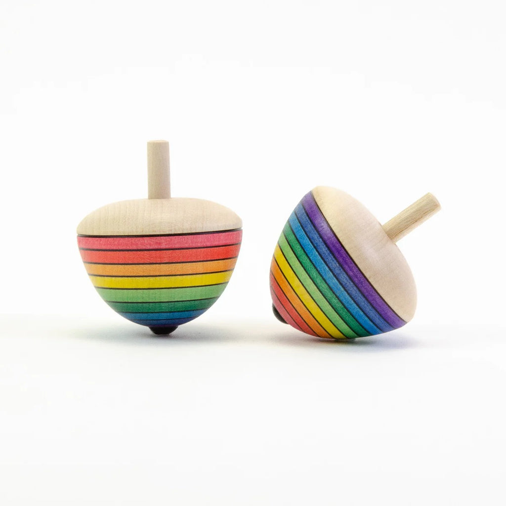 Two rainbow-colored wooden spin tops on a white background