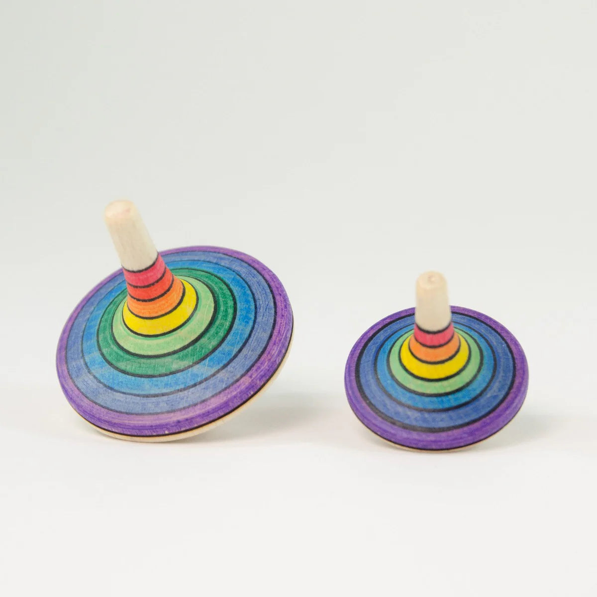 Two colorful wooden spinning tops on a white background