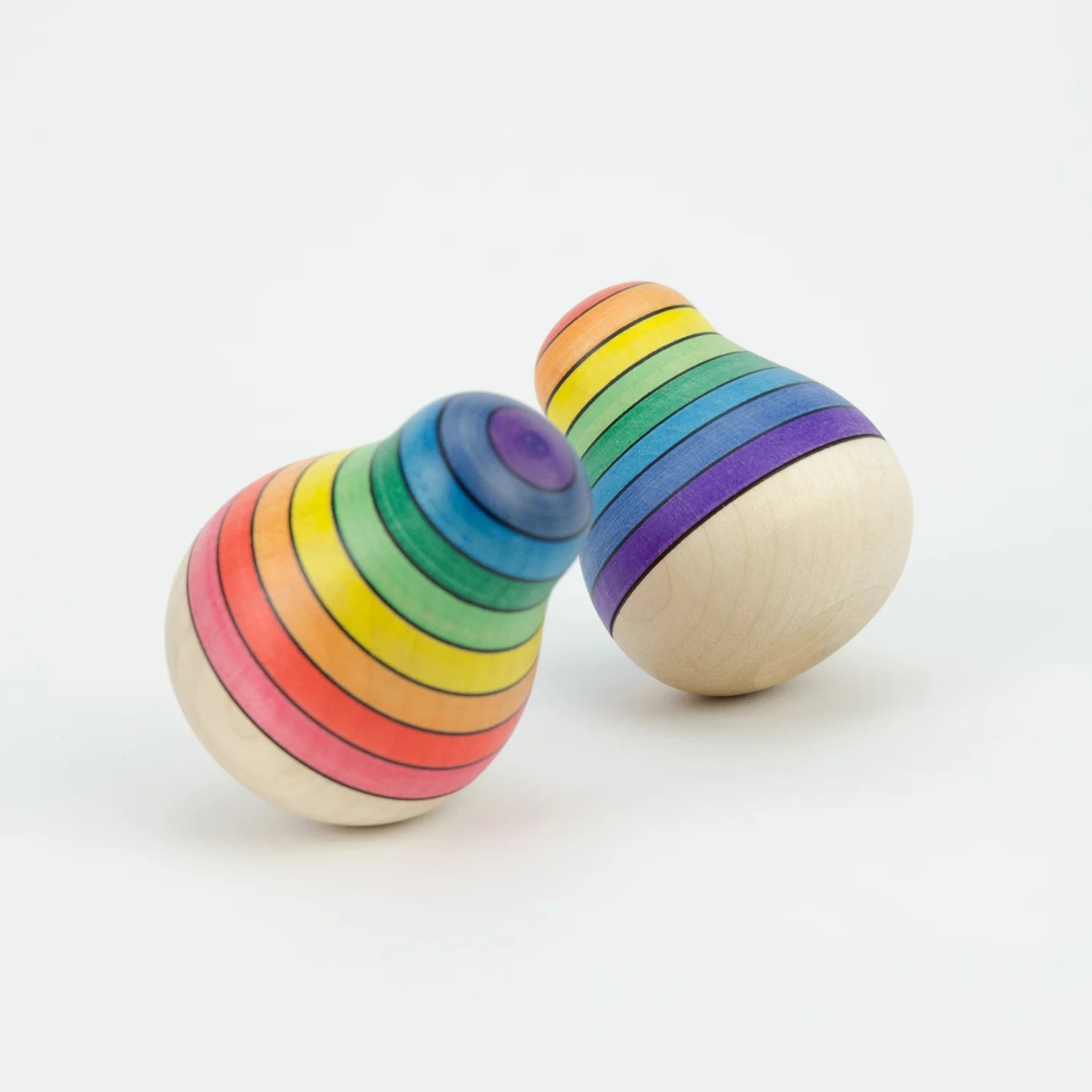 Two wooden rainbow toys stacked on a white background